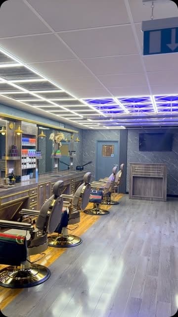 Inside Nwah Trims: a row of barber chairs under blue and white ceiling lights